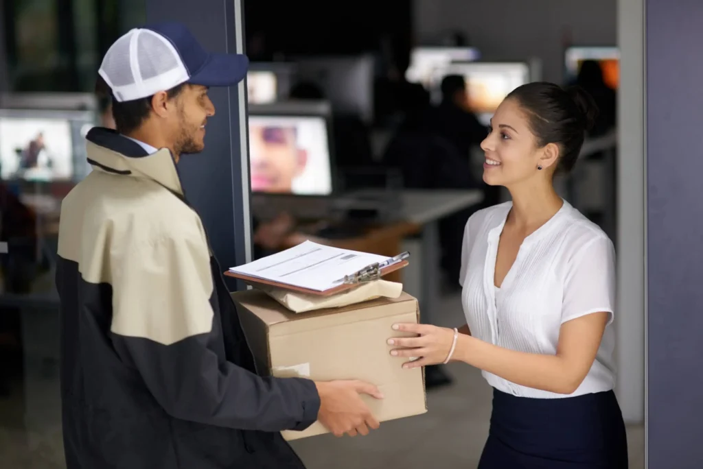 delivery person handing package to office worker at doorway