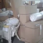 various packed boxes and wrapped furniture items stored in a warehouse